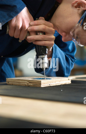 Worker using drill in factory Stock Photo