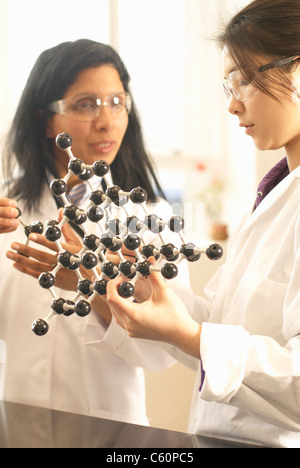 Scientists examining molecular model Stock Photo