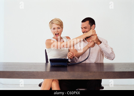 Business people fighting over telephone Stock Photo
