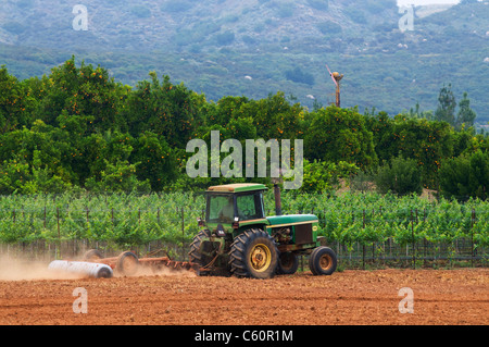 Tractor cultivating field Stock Photo