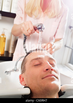 Hairdresser washing man’s hair Stock Photo