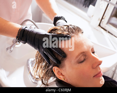 Hairdresser washing woman’s hair