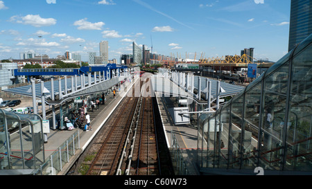 A view looking east of empty rail tracks with passengers waiting for the DLR train at Poplar Station East London UK KATHY DEWITT Stock Photo