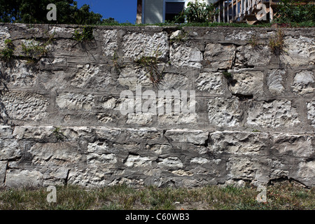 Late 19th or early 20th century limestone or sandstone block wall with lined mortar and primitive toolmarks. Stock Photo