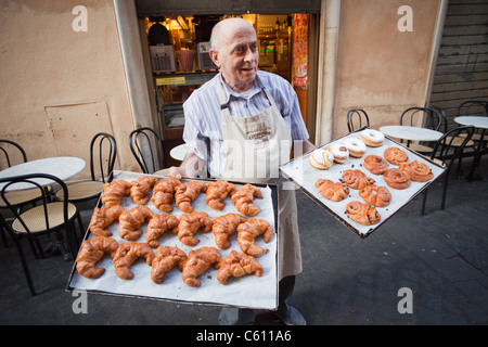 Italy, Rome, Baker Holding Trays of Pastries and Croissants Stock Photo