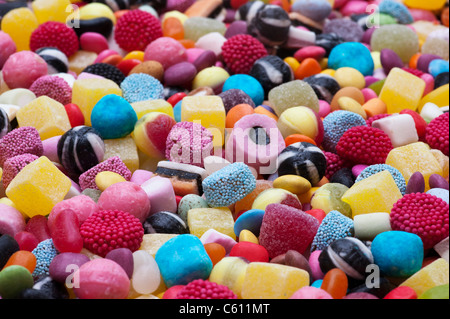 Colourful assorted childrens sweets and candy. Liquorice allsorts, Smarties, pineapple cubes, humbugs, bonbons, dolly mixtures and jelly beans Stock Photo