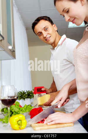 Portrait of amorous couple cooking salad in the kitchen Stock Photo
