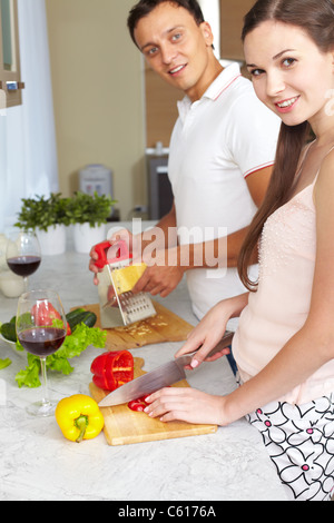 Portrait of amorous couple cooking salad in the kitchen Stock Photo