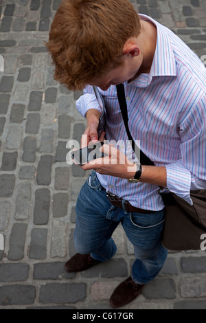 Young man using mobile smart phone to check Edinburgh Fringe Festival programme on internet Stock Photo