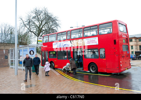 Passengers boarding a red double decker bus in Transdev livery waiting at a bus stop. Stock Photo