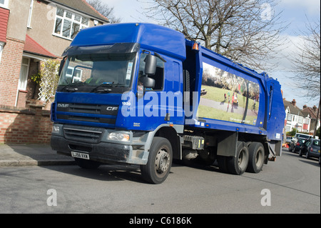 Waste disposal lorry collecting domestic refuse in a street in England. Stock Photo