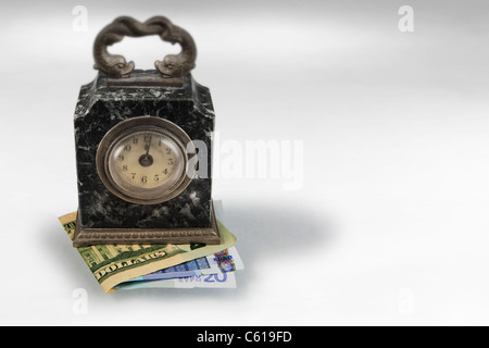 one minute past midnight antique clock placed on Euro and US banknotes, symbolizes necessity  to protect investment against...