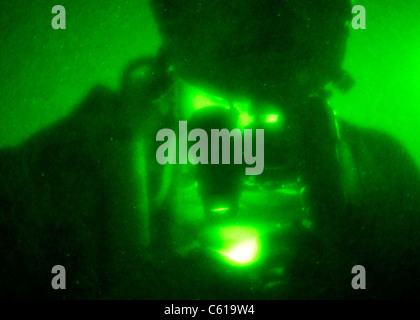 A U.S. Navy SEAL surveys a map of the objective area during a village clearing operation in Shah Wali Kot district, Kandahar province, Afghanistan, June 7, 2011. Operations such as these are conducted in order to deny Taliban influence and promote the Government of Afghanistan, while providing security and stability throughout the province. The SEALs are with Special Operations Task Force ? South. (U.S. Army photo by Sgt. Daniel P. Shook/Released) Stock Photo