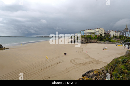 The sandy beach at Tenby in Wales with few holiday makers and ice-cream van on a cold and stromy summers day. Stock Photo