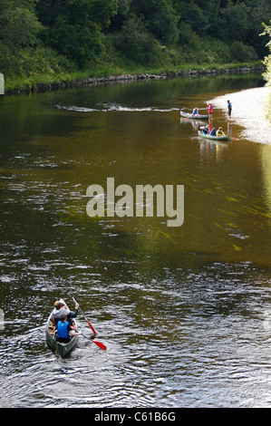 Adults and children canoeing  down the river Wye in open type Canadian canoes. Stock Photo