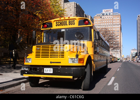 Canadian school bus parked outside university building awaiting passengers in Toronto Canada Stock Photo