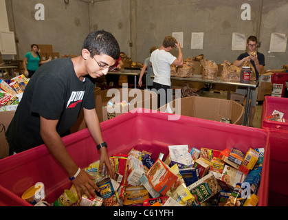 Teens volunteer sorting cans of food in the warehouse of the San Antonio Food Bank in San Antonio, Texas Stock Photo