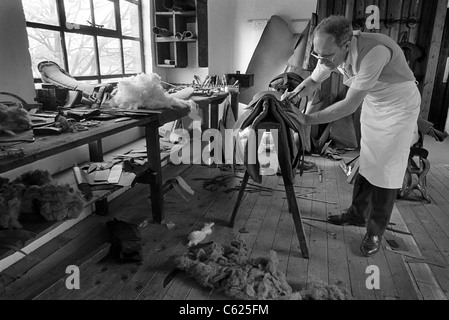 Master saddler Frank Baines at work in his Walsall workshop making a horse's saddle. vintage black and white image. Stock Photo