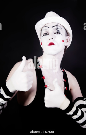 theater actor in makeup and a white hat on a black background Stock Photo