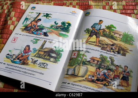 An instructional book produced for tobacco pickers by a cigarette company rests on the floor of a rural home in Cambodia. Stock Photo