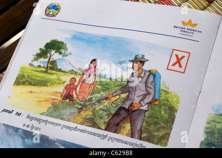 An instructional book produced for tobacco pickers by a cigarette company rests on the floor of a rural home in Cambodia. Stock Photo
