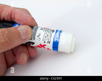 Pritt stick gum glue for paper held in a man's hand Stock Photo