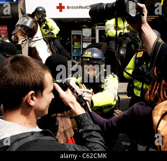 Smoke bombs are let off as Anti Arms protesters and police some on horses clash in London Road Brighton for Mayday protest Stock Photo