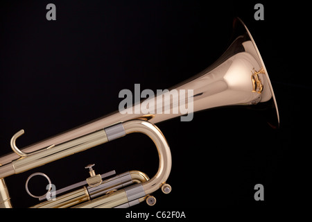 A gold and brass trumpet or cornet isolated against a black background. Stock Photo