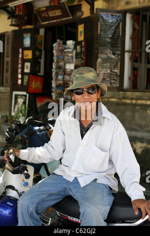 Portrait of Vietnamese man sitting on motorbike. Stock Photo
