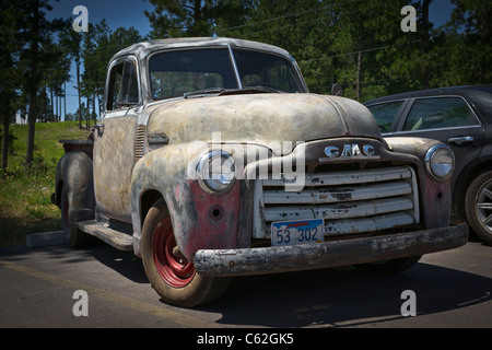 An old worn out GMC classic truck with faded paint job parked on a parking lot in Hill City South Dakota USA US horizontal hi-res Stock Photo