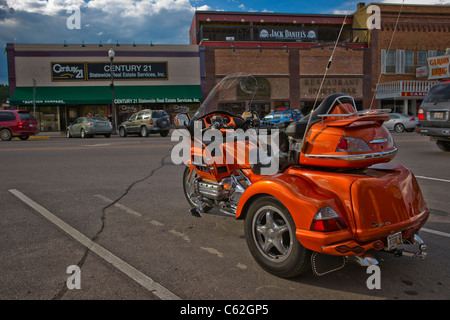 Low angle view of historic downtown with Honda Goldwing Trike in foreground  in Custer South Dakota USA against a dramatic sky hi-res Stock Photo