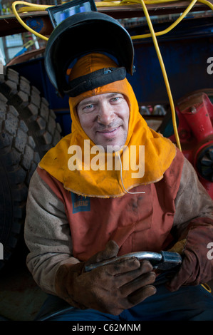Welder boilermaker at work on the chassis of a heavy vehicle in Port Hedland Western Australia Stock Photo