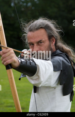 Archer taking aim with a Lemonwood and Hickory Longbows, English longbow and arrows, weapon, accuracy, concentrate, fighter, aim, target, sport, shoot, hunt, aiming, precision, vector, archers at the Northwich Medieval Festival Verdin Park, Cheshire13th August 2011 - 14th August 2011, UK Stock Photo