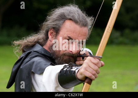 Archer taking aim with a Lemonwood and Hickory Longbows, English longbow and arrows, weapon, accuracy, concentrate, fighter, aim, target, sport, shoot, hunt, aiming, precision, vector, archers at the Northwich Medieval Festival Verdin Park, Cheshire13th August 2011 - 14th August 2011, UK Stock Photo