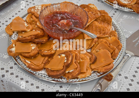 This traditional Norwegian food, is a silver platter of heart shaped waffles with slices of brown goat cheese on top. Stock Photo