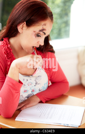 Woman filling out injury claim form Stock Photo