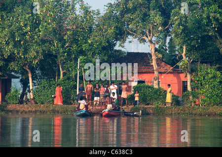 Villagers watching fishermen in early morning light Backwaters Kerala South India Stock Photo