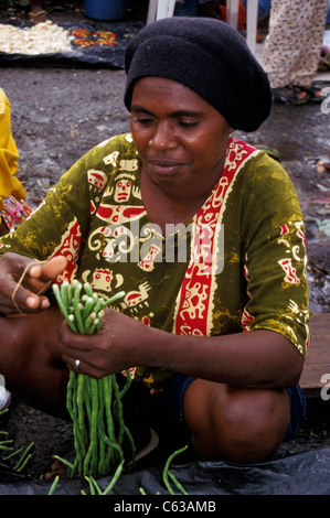 Faces in the market at Timika:  big-boned, frizzy haired Melanesia nmen and women preside over pyramids of produce. Timika, West Papua, Indonesia Stock Photo