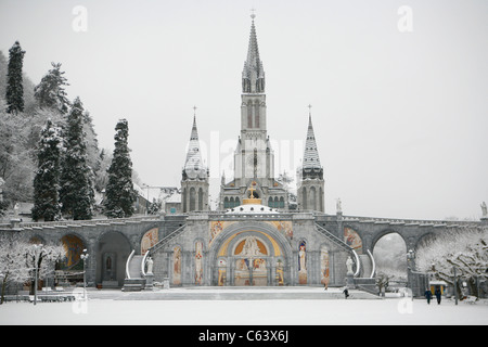 Lourdes in winter: Basilica of the Immaculate Conception and the Rosary Basilica, Sanctuary of Lourdes. Stock Photo