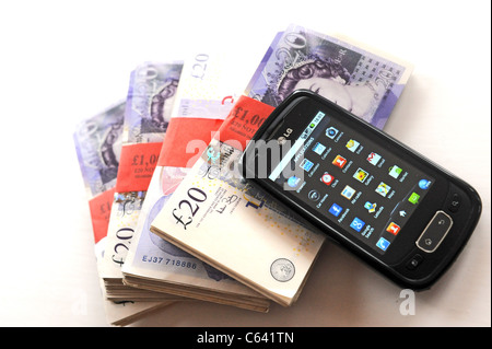 LG Mobile smart phone and wads of British sterling £20 notes to illustrate internet banking UK 2011 Stock Photo