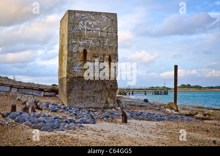 A large concrete block on a beach covered in graffiti. Stock Photo