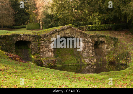 The rustic stone arches of the lower cascade within the Venus Vale of Rousham House gardens, Oxfordshire, England Stock Photo