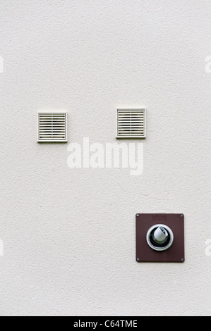 Wall-mounted ventilation outlets and the flue from a gas boiler, on the outside wall of a modern domestic property Stock Photo