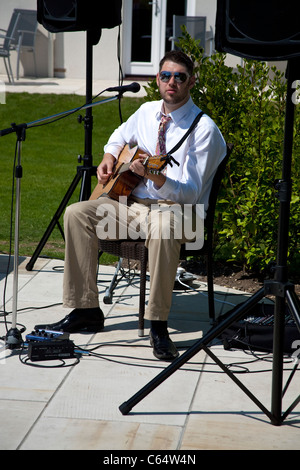 solo guitarist at a wedding venue wearing dark glasses Stock Photo