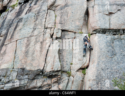 A male rock climber climbing in traditional style in Lofoten Islands, Norway Stock Photo