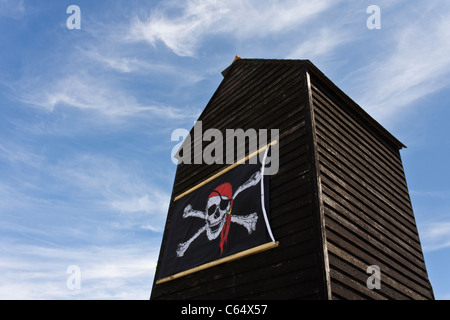 A skull and crossbones pirate flag on the side of a Net Shop in Hastings, Sussex. Stock Photo