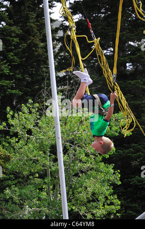 A youngster enjoys doing a somersault on the bungy trampoline at Snowbird Stock Photo