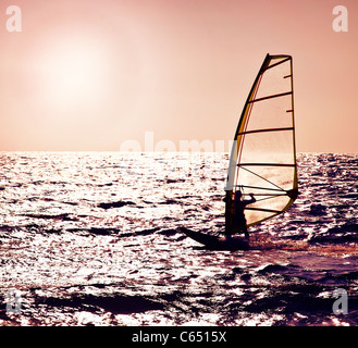 Windsurfer silhouette over sea sunset, beautiful beach landscape, summertime fun, sport, activities, vacation and travel concept Stock Photo