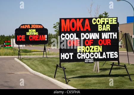 roadside luminous writing advertising signs in Saskatoon Saskatchewan Canada Stock Photo