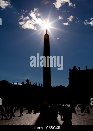 Sun star silhouettes the obelisk in St Peters Square, Vatican City, Rome, Italy. Stock Photo